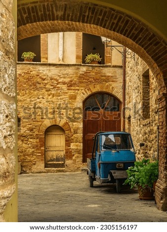 An old three-wheeler on the cobbled streets of San Quirico d'Orcia Royalty-Free Stock Photo #2305156197