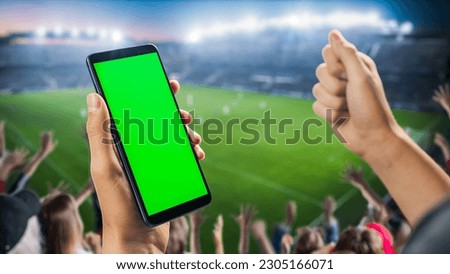 International Soccer Football Championship on Stadium: Fan on Tribune Holding Smartphone With Green Screen Chromakey Display, Cheering for Favourite Team. Isolated POV Close-Up Copyspace Template