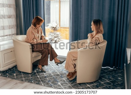 Two businesswoman having a meeting. Two young women talking in a consultation. Female colleagues in office working together. Two beautiful business women working together while talking about job news. Royalty-Free Stock Photo #2305173707