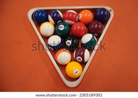 Billiards is a cue sport played on a table with balls, where players use cues to strike the balls into the pockets. It requires skill, strategy, and precise shot-making to win. Royalty-Free Stock Photo #2305189301