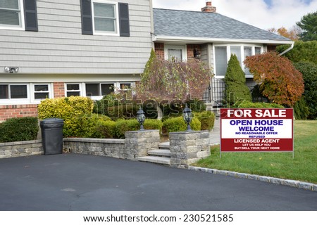 Real Estate For Sale Open House Welcome sign on front yard lawn of suburban high ranch style home residential neighborhood USA