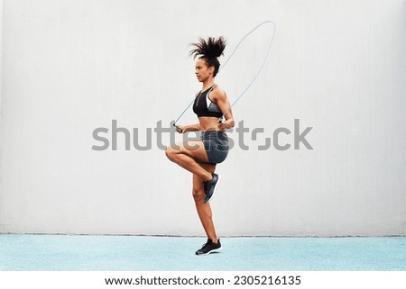 Jump, skipping rope and training with woman in stadium for sports, workout practice and cardio. Performance, health and body with female athlete jumping on track for strong, mockup space and exercise Royalty-Free Stock Photo #2305216135
