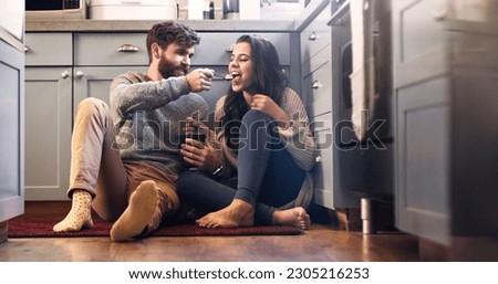 Ice cream, kitchen and couple on floor in home for bonding, relaxing and quality time together. Love, relationship and happy man and woman with sweet treats, dessert and luxury snack for romance Royalty-Free Stock Photo #2305216253