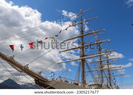 Wooden sailing boat with flags of nations. Blue sky background. Picture taken in Ushuaia.