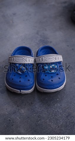 close up photo of blue children's sandals with a picture of Tayo's bus
