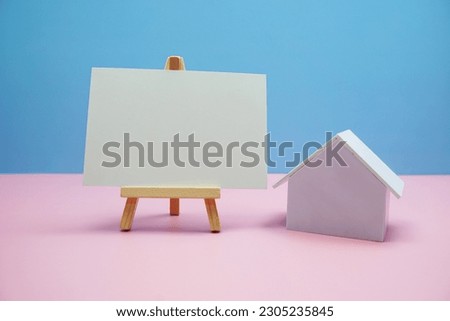 House model with empty paper card for copy text message on pink and blue background