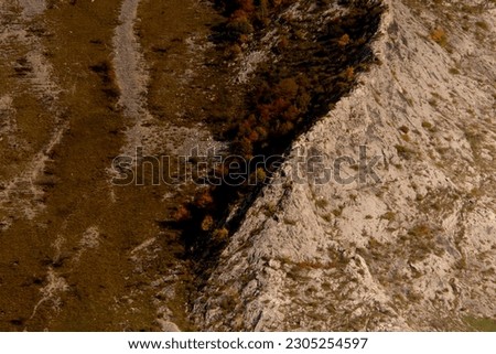 An aerial shot of the rocky big mountains and mountainsides during the autumn season