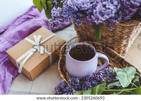 Cup of tea, gift box and lilac basket, spring still life.