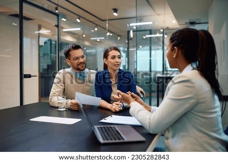 Young couple talking to their financial advisor during a meeting in the office. Royalty-Free Stock Photo #2305282843