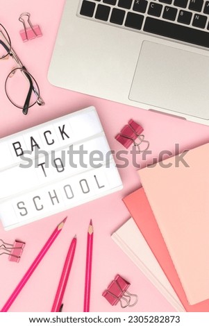 Back to school. Lightbox, laptop and office supplies on a pink background. Workspace for online education.
