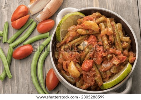 Arabic Cuisine; Egyptian traditional green bean stew. A delicious vegan meal with fresh green beans doused in aromatic tomato sauce. Royalty-Free Stock Photo #2305288599