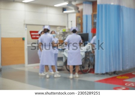 Medical doctor team at the bedside of patient, unfocused background.