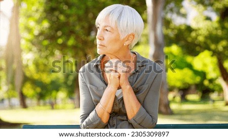 Tired, thinking and a sad woman in a park with depression, mental health problem and anxiety. Ideas, praying and a senior person sitting in nature with a prayer, hope and thoughtful while depressed Royalty-Free Stock Photo #2305309897