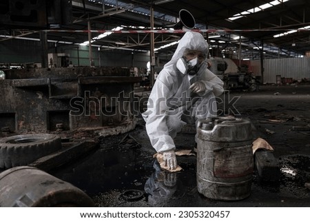 person in mask. Hazardous control related to factory chemicals. Employees are disposing of harmful substances. in a chemical protective suit in a factory Royalty-Free Stock Photo #2305320457