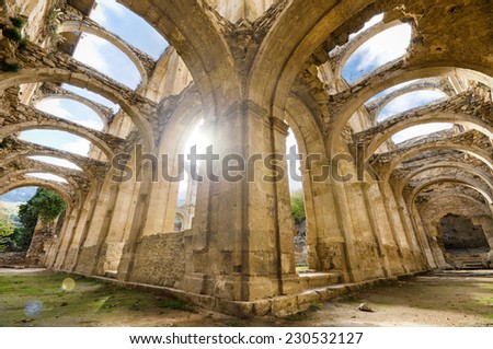 Scenic view of the ruined cloister of an abandoned monastery. HDR picture with ray of light and lens flare effect.