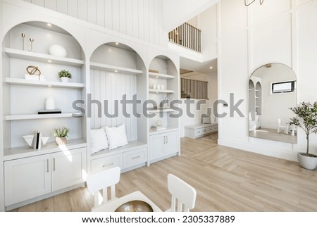 Living room interior with white decor arched mirror and built in shelving warm white tone minimalist Royalty-Free Stock Photo #2305337889