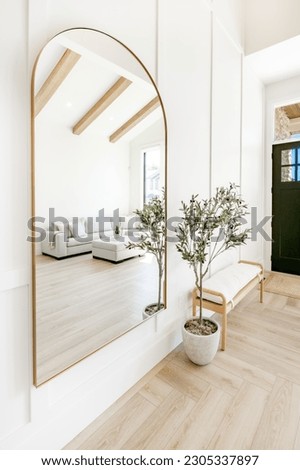 Living room interior with white decor arched mirror and built in shelving warm white tone minimalist Royalty-Free Stock Photo #2305337897