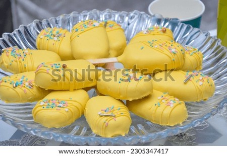 A plate of cake balls with yellow cream, close-up. Candy bar and catering concept for birthday, wedding and other holiday celebrations