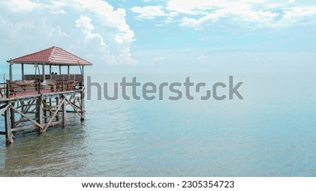 Scenic view of ocean pier and sandy beach with beautiful blue sky and copy space