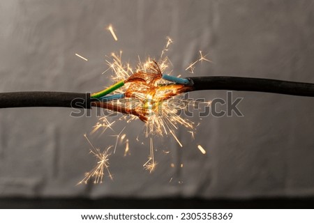 sparks explosion between electrical cables, fire hazard concept, soft focus close up Royalty-Free Stock Photo #2305358369