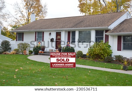 Sold Real Estate (another success let us help you buy sell your next home) sign on front yard of suburban ranch style home residential neighborhood autumn season USA