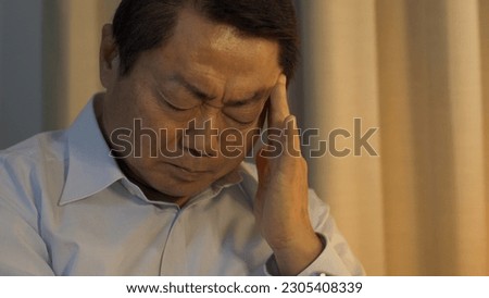 Middle-aged man with headache at night Royalty-Free Stock Photo #2305408339