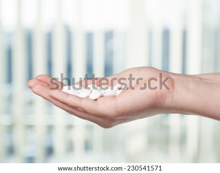 Hand with white pills.