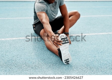 Athlete, sitting and track for stretching legs to start training, exercise or running for fitness outdoor. Man, runner and warm up for muscle, body and wellness at stadium for race, contest or sports Royalty-Free Stock Photo #2305426627