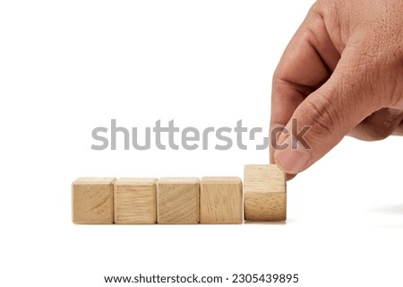 man hand establishes wooden cubes in a row