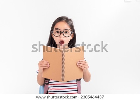 schoolgirl hugging book wearing backpack smiling isolated on white background
