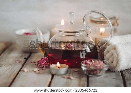 Aromatherapy. Bath salt, pure natural essential oils, floral rose extract. Spa treatment, skin care, relaxation with burning candles, herbal organic hot tea. Towel, wooden background Royalty-Free Stock Photo #2305466721