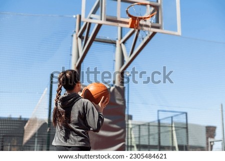 beautiful girl shooting basket and playing basketball