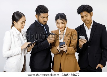 Millennial Asian young cheerful professional successful female businesswoman in formal business suit showing data from smartphone to Indian businessman while colleages working on white background.