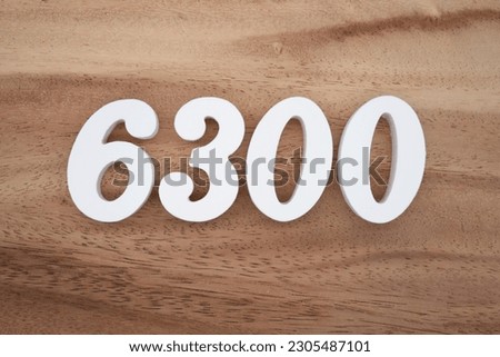 White number 6300 on a brown and light brown wooden background.