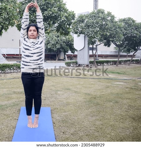 Young Indian woman practicing yoga outdoor in a park. Beautiful girl practice basic yoga pose. Calmness and relax, female happiness. Basic Yoga Exercise outdoor