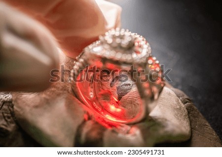 engraving carving character on ring by high power laser beam spark on surface metal ring and jewelry. Closeup of machine engraving carving character on metal ring by laser beam. Royalty-Free Stock Photo #2305491731