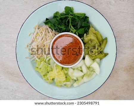Pecel. In the form of several vegetables such as spinach, bean sprouts, cucumber, turi flowers and chicory mixed with peanut sauce. Boiled vegetables are placed on a plate. Indonesian food. Top view.