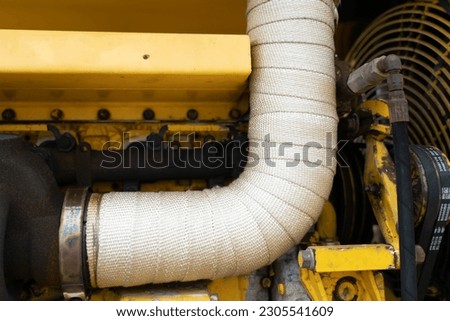 Heat-resistant fiberglass cloth around the crane exhaust pipe Royalty-Free Stock Photo #2305541609