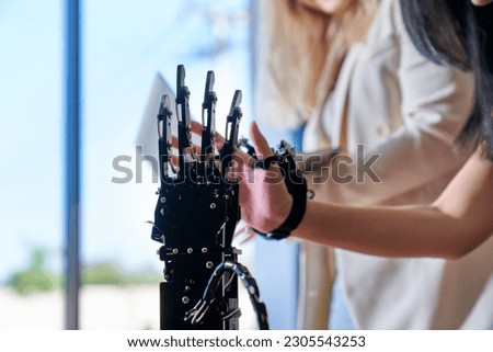 Robotic hand and student girl in science classroom for learning AI and control its.