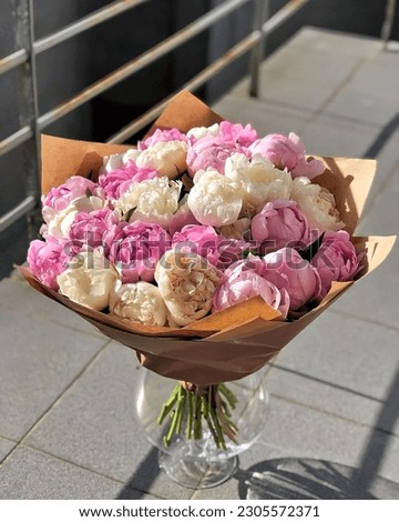 flowers decorated with pink bow standing on the floor outside, A roses bouquet beautiful put