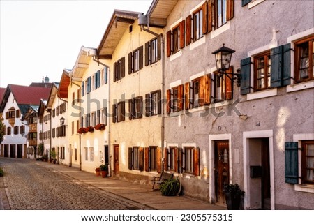 Bavarian houses lined up in vanishing point perspective in the warm afternoon light of the sun Royalty-Free Stock Photo #2305575315