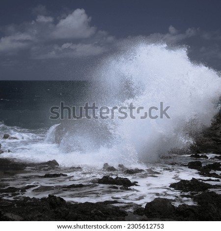 Gran Canaria, north west coast around natural swimming pools Salinas de Agaete, 
waves breaking against old eroded dark lava platform Royalty-Free Stock Photo #2305612753