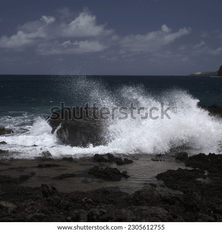 Gran Canaria, north west coast around natural swimming pools Salinas de Agaete, 
waves breaking against old eroded dark lava platform Royalty-Free Stock Photo #2305612755