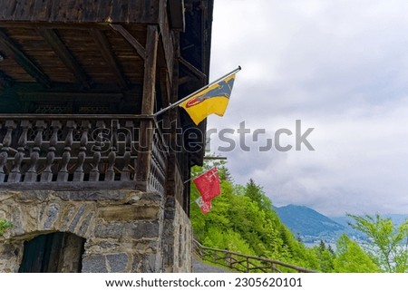 Chalet with waving flags at Rütli meadow where the  foundation of historic Switzerland took place by the three cantons Uri, Schwyz and Unterwalden. Photo taken May 18th, 2023, Rütli, Switzerland.