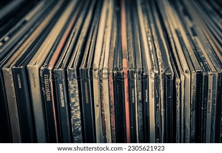 Stack of old vinyl records on a dark background. Selective focus. Toned.