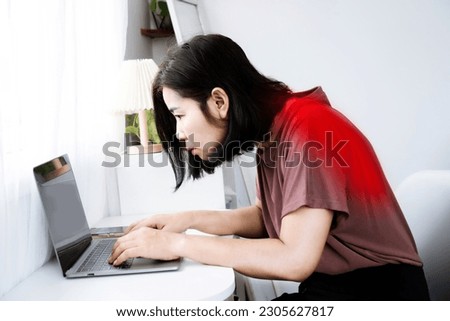 Asian woman's back and shoulder pain with incorrect posture while working on a computer and potential Kyphosis Royalty-Free Stock Photo #2305627817