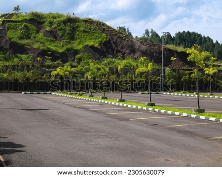 parking area with green hills and blue sky in the background