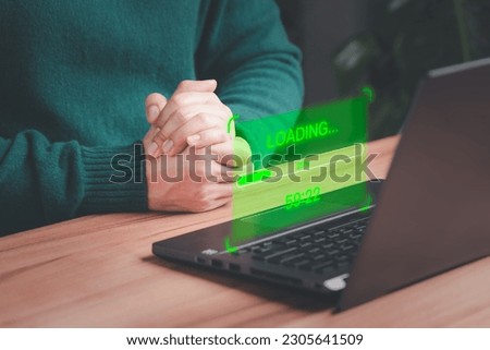 User man using a laptop computer for download and update software with waiting to loading digital file data form website, very slow internet form wifi. Concept of waiting for load of loading symbol.