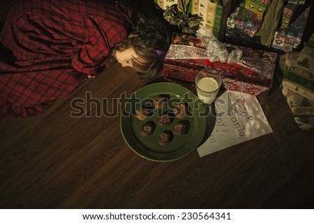 a cute little girl / tires from waiting for santa / and now she's asleep