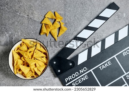 clapper board of video cinema in studio and  bowl of cone corn chips  on gray grunge background